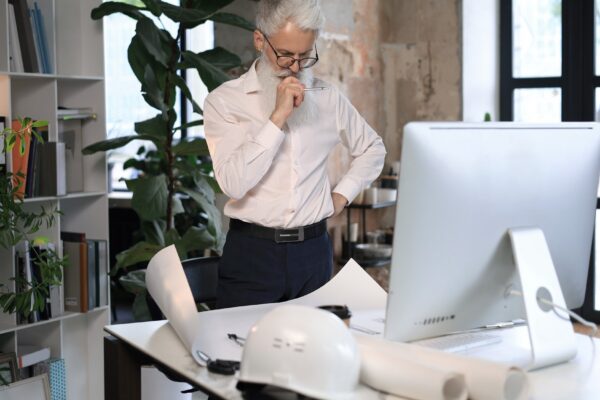 Good looking mature architect drawing something while working in the office.
