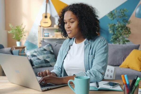 Woman working on a laptop in a cozy living room.