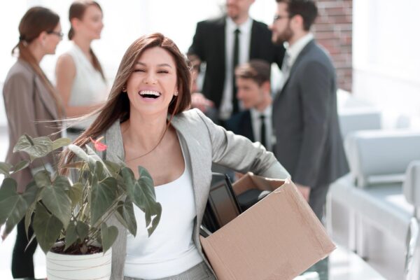 Happy young business woman standing in new office