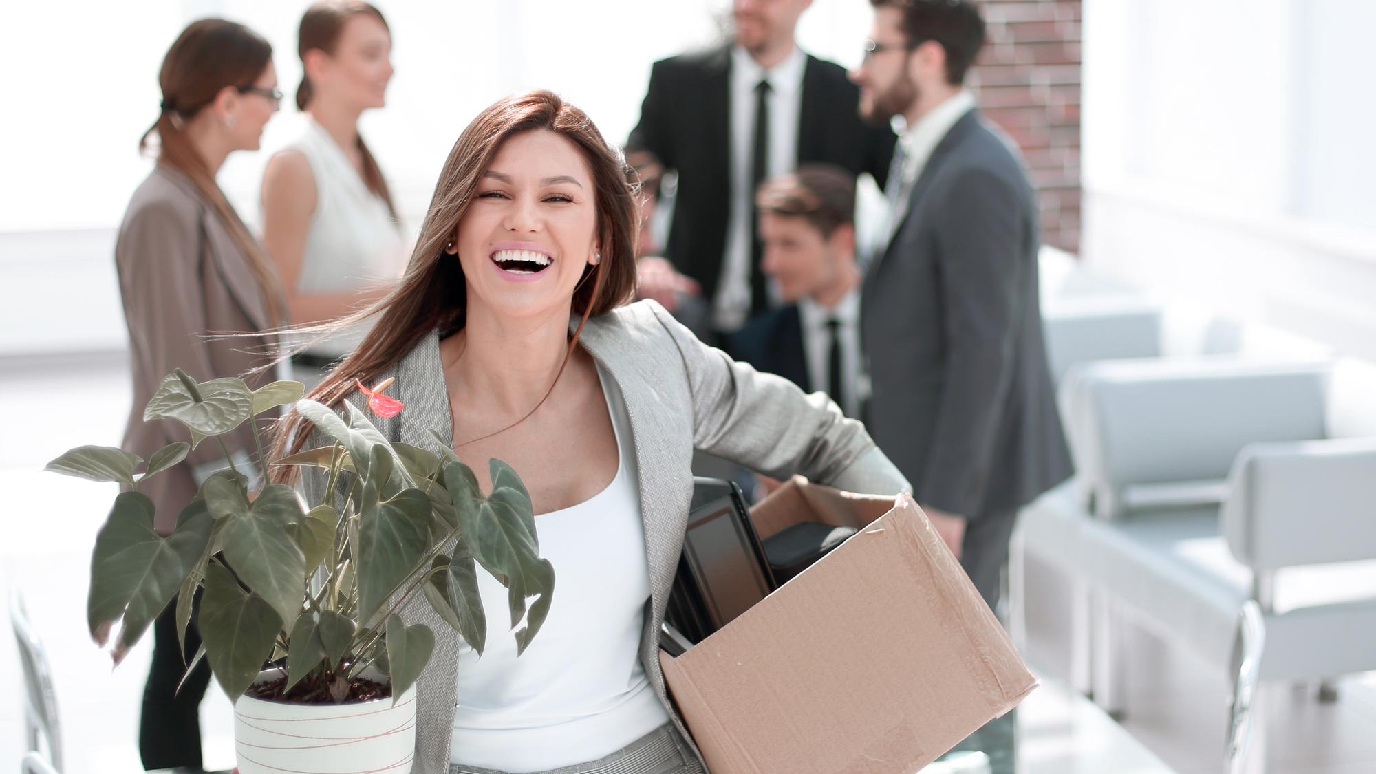 Happy young business woman standing in new office