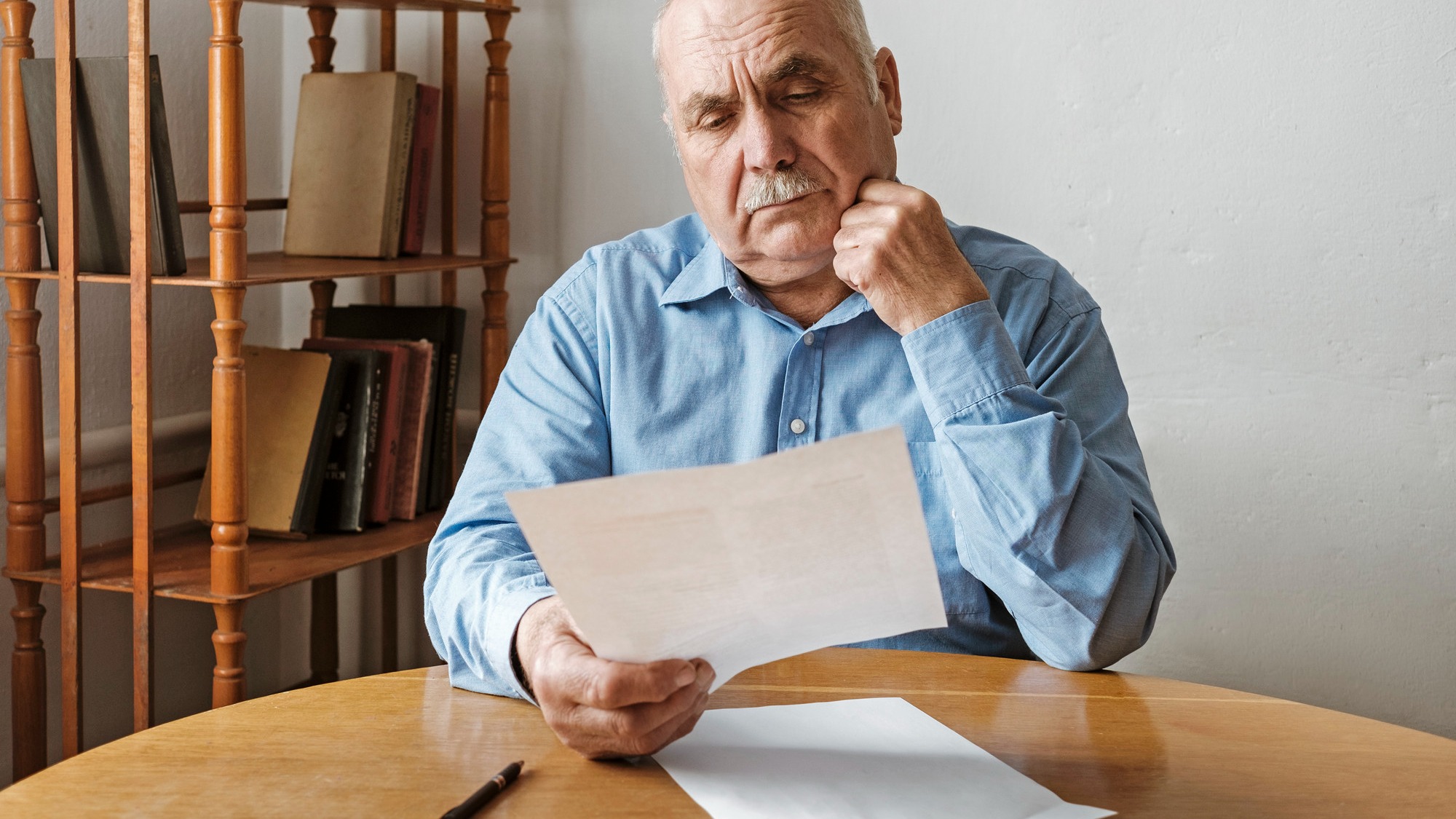 Thoughtful old man reading a paper document