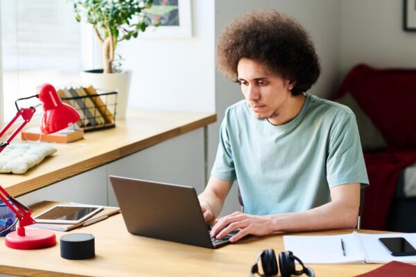 Young man working online on laptop at home