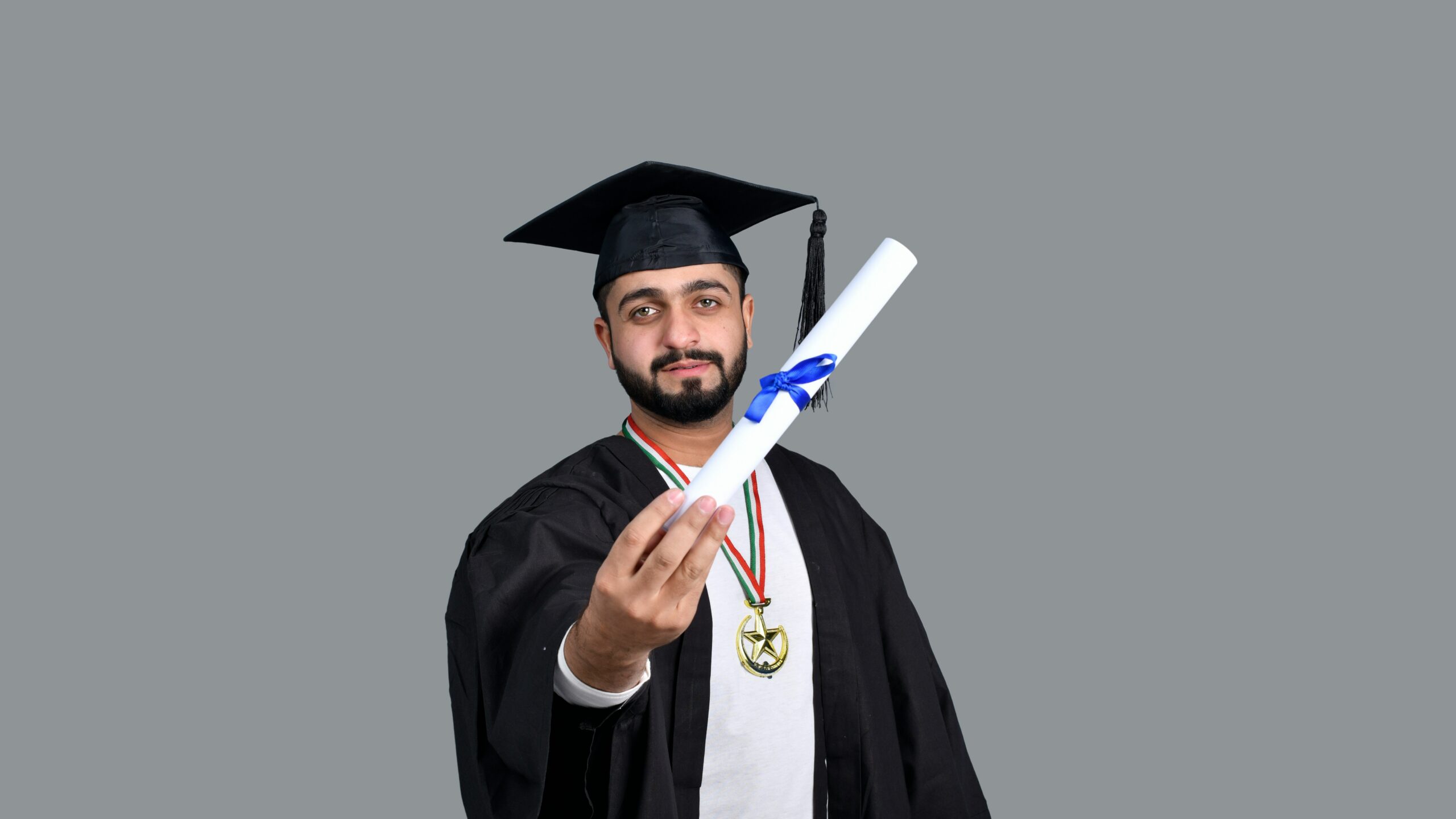 a man wearing a graduation cap and gown holding a diploma