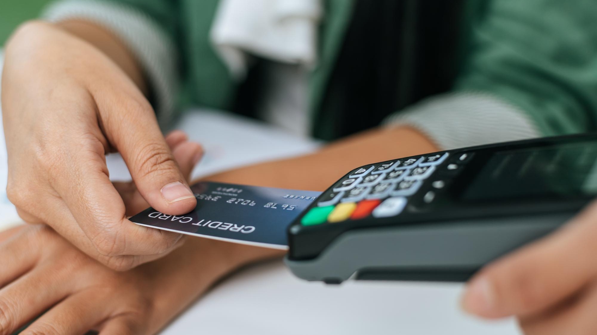 Young businesswoman paying order having contactless payment with cardit card