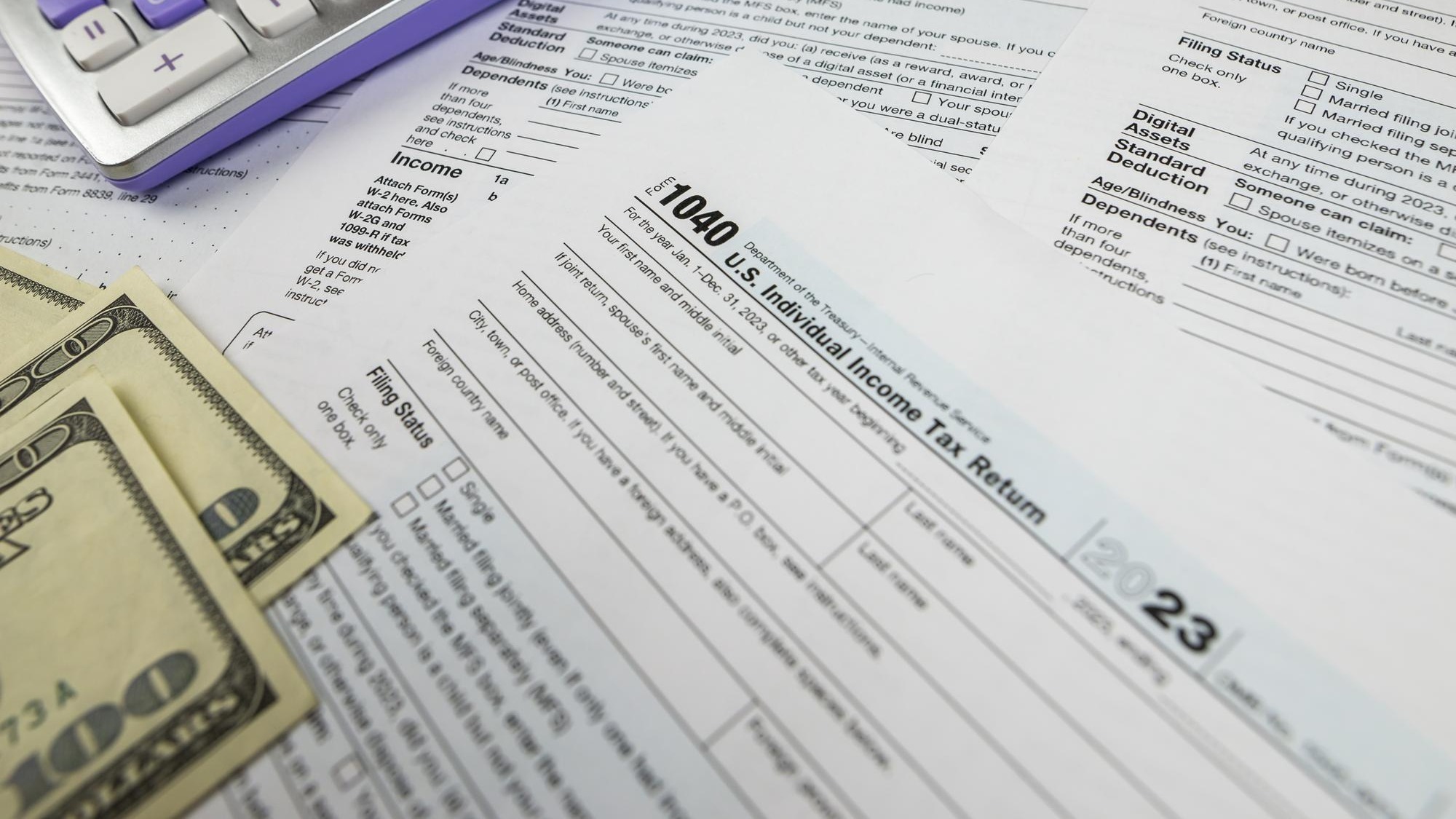 Tax form 1040 with calculator and dollars