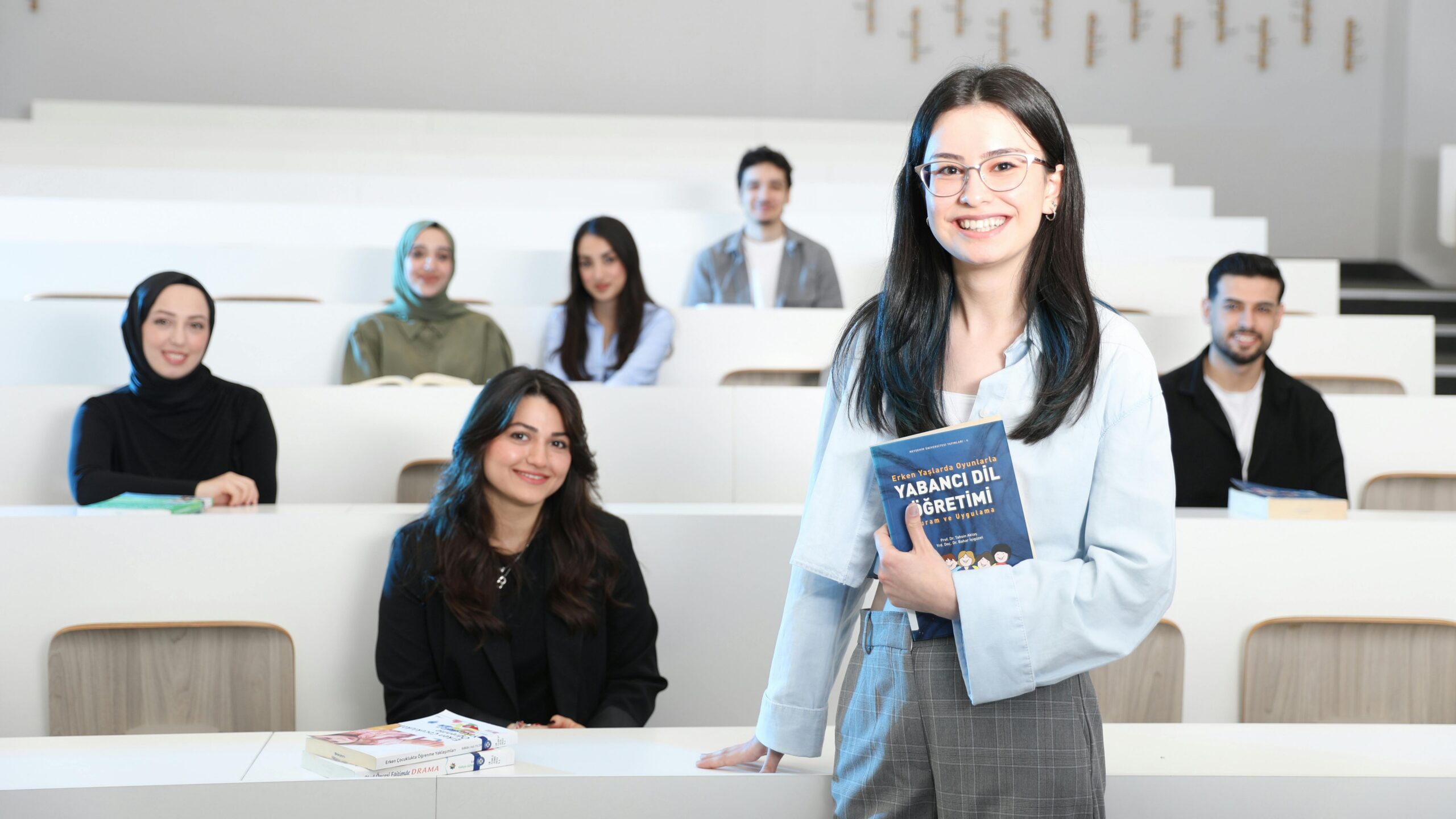 Group of diverse university students in a bright lecture hall, studying language education.