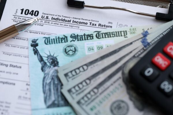 United States 1040 tax form individual income tax return with refund check and US dollar bills
