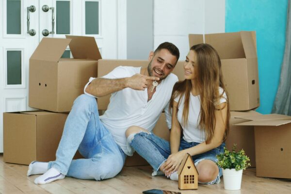 Couple sitting among moving boxes in new home