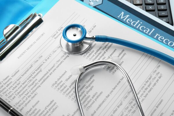 A stethoscope calculator and clipboard closeup