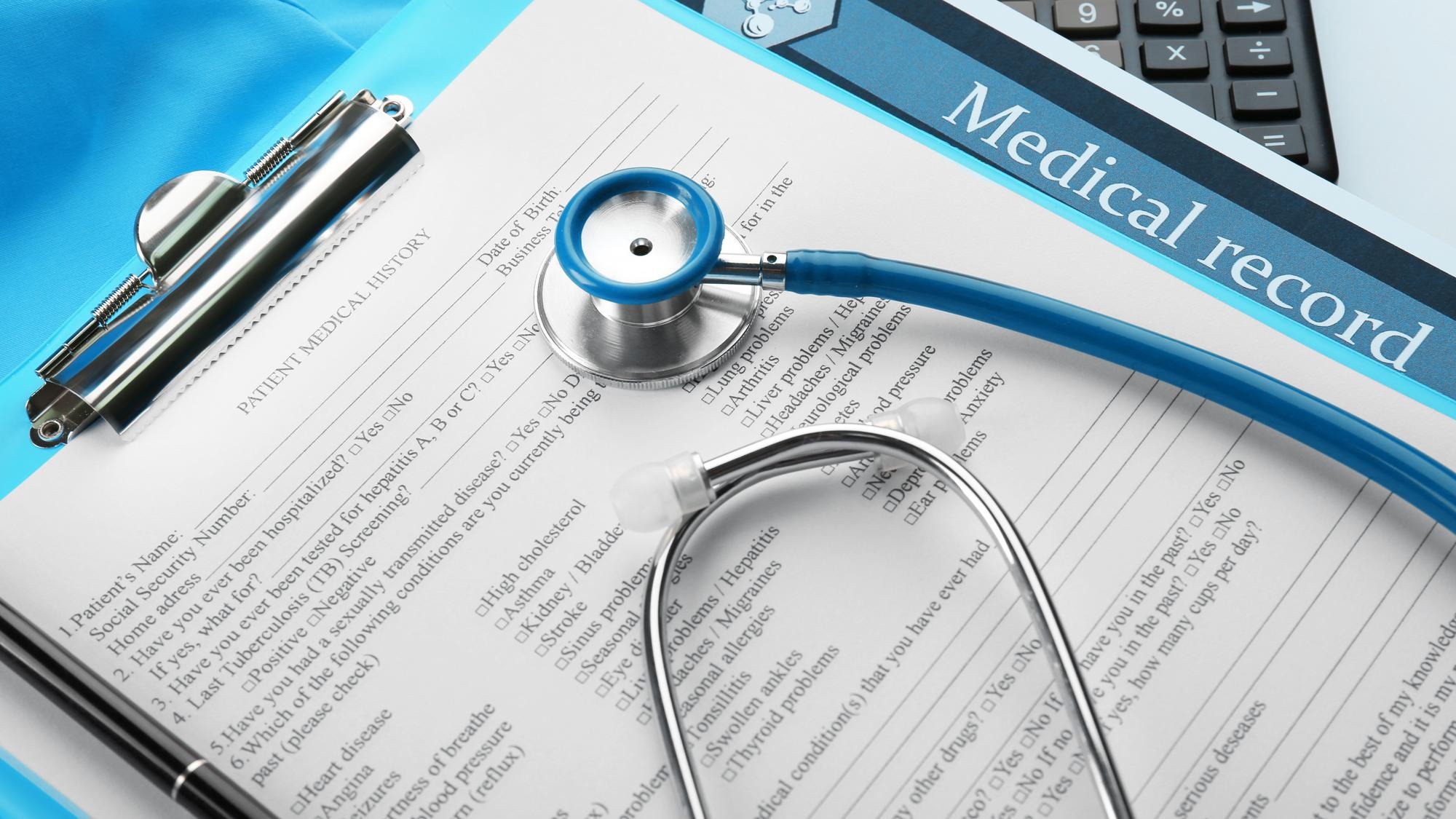 A stethoscope calculator and clipboard closeup
