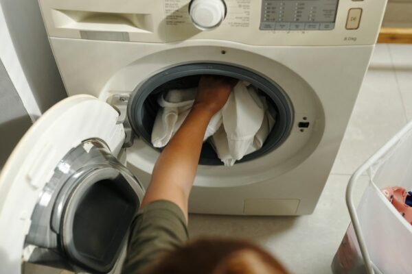 Loading Washing Machine with Laundry in Modern Laundry Room