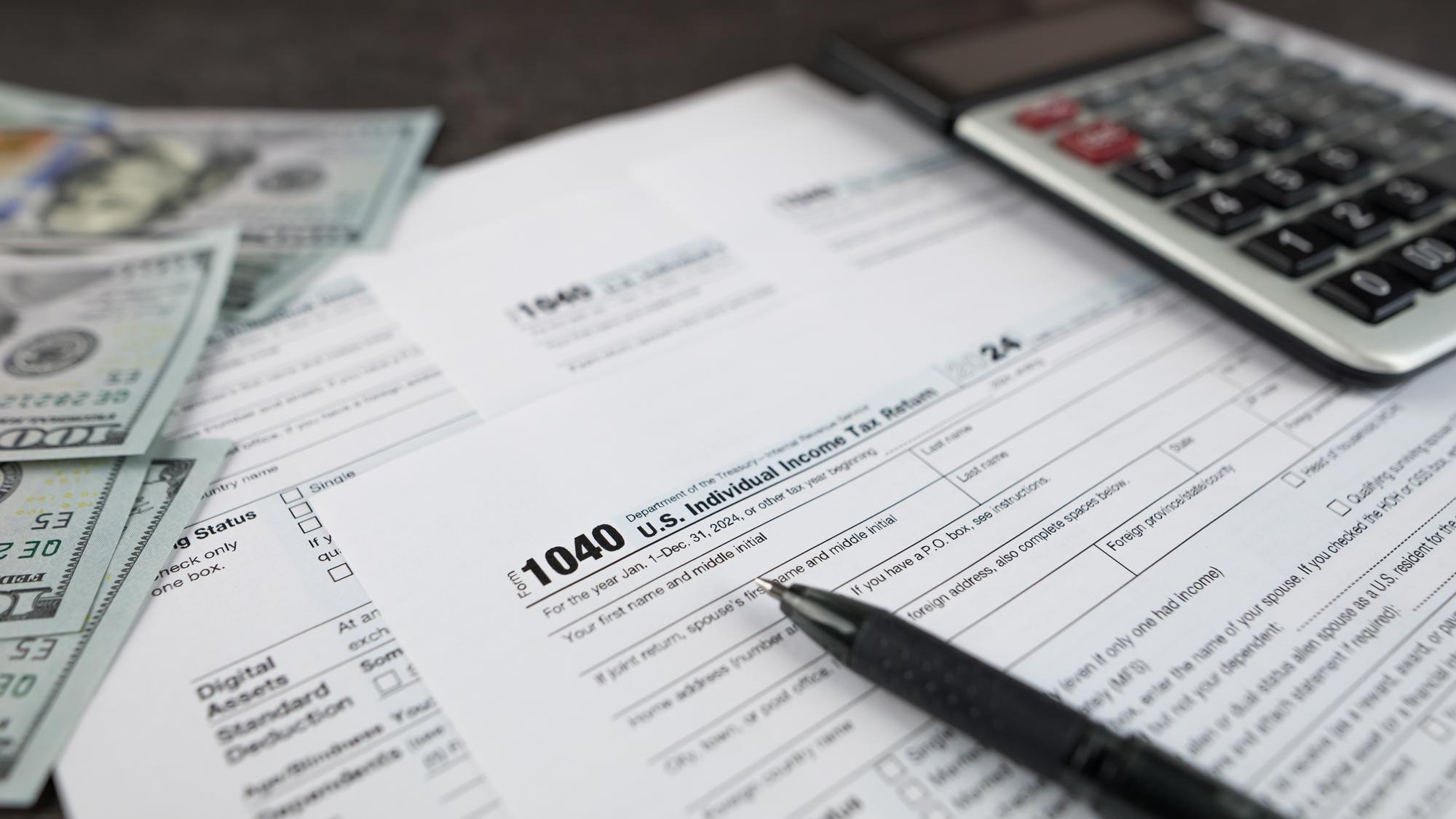 Tax form 1040 on dark wooden background financial document