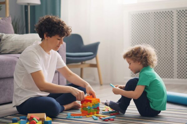 a man and a child playing with blocks on the floor