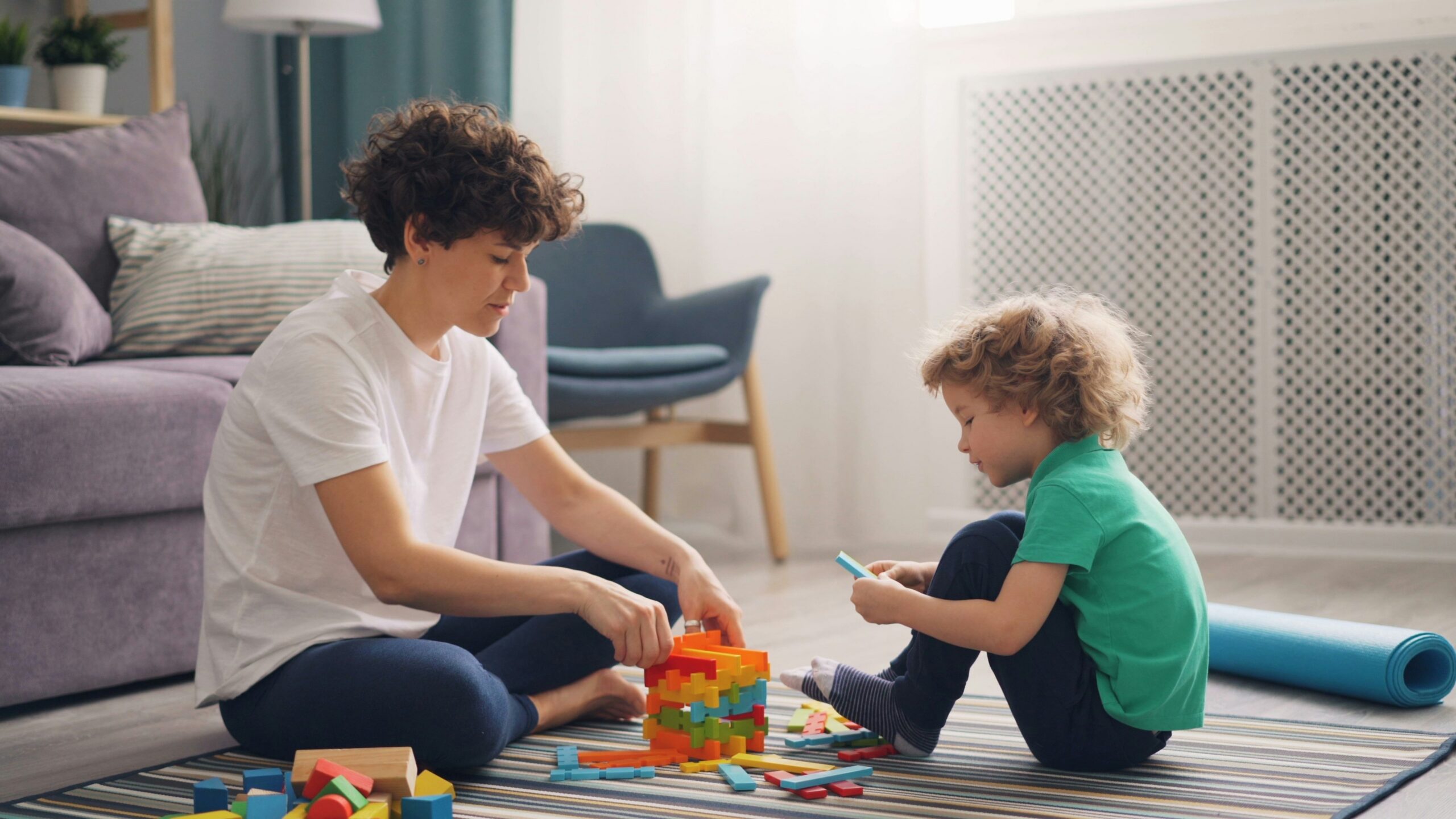 a man and a child playing with blocks on the floor