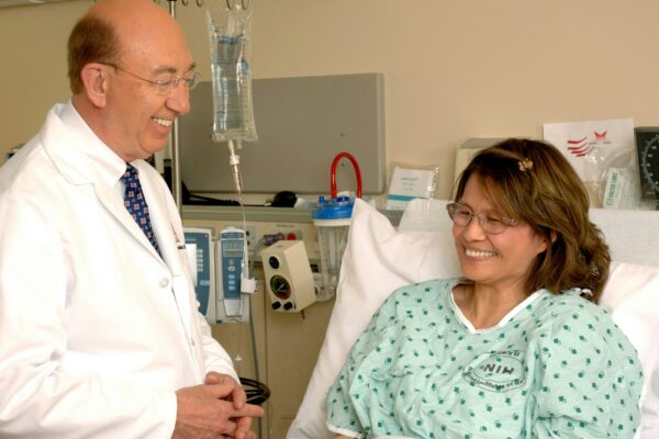 woman in teal scrub suit sitting beside man in white medical scrub suit