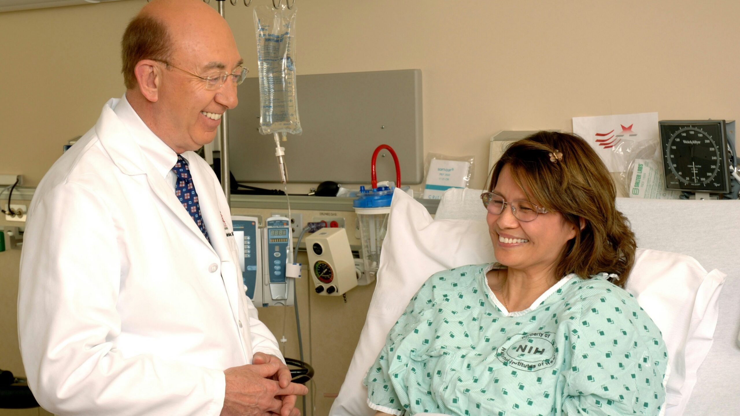 woman in teal scrub suit sitting beside man in white medical scrub suit