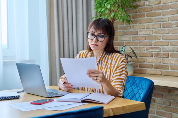 Mature business woman working at desk in home office using laptop