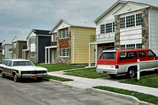 a row of houses with cars parked in front of them