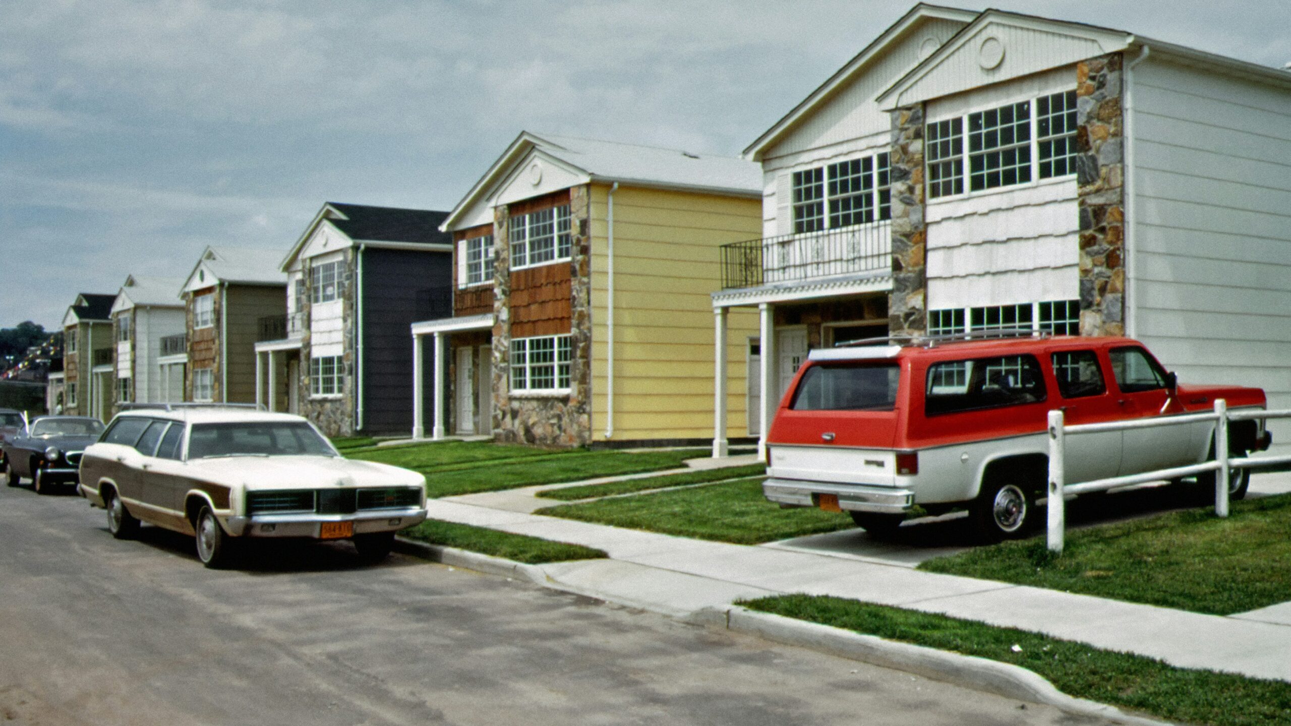 a row of houses with cars parked in front of them