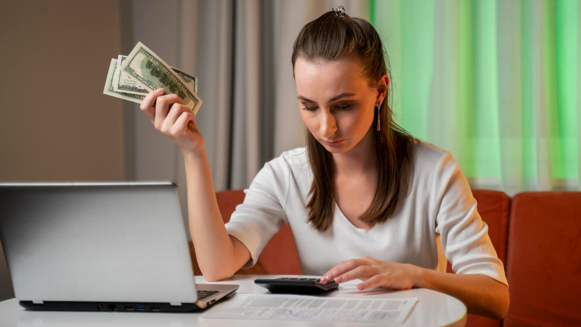 A young woman who is in a state of stress calculates monthly housing costs and installments for a ca