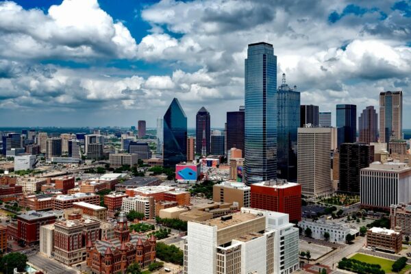 A stunning panoramic view of the Dallas skyline under dramatic clouds, capturing the city's iconic skyscrapers.