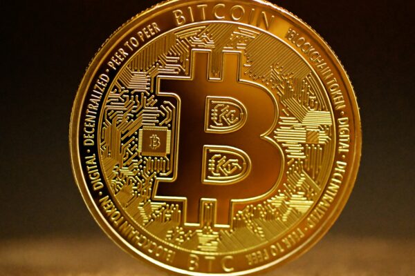 a golden bitcoin sitting on top of a table