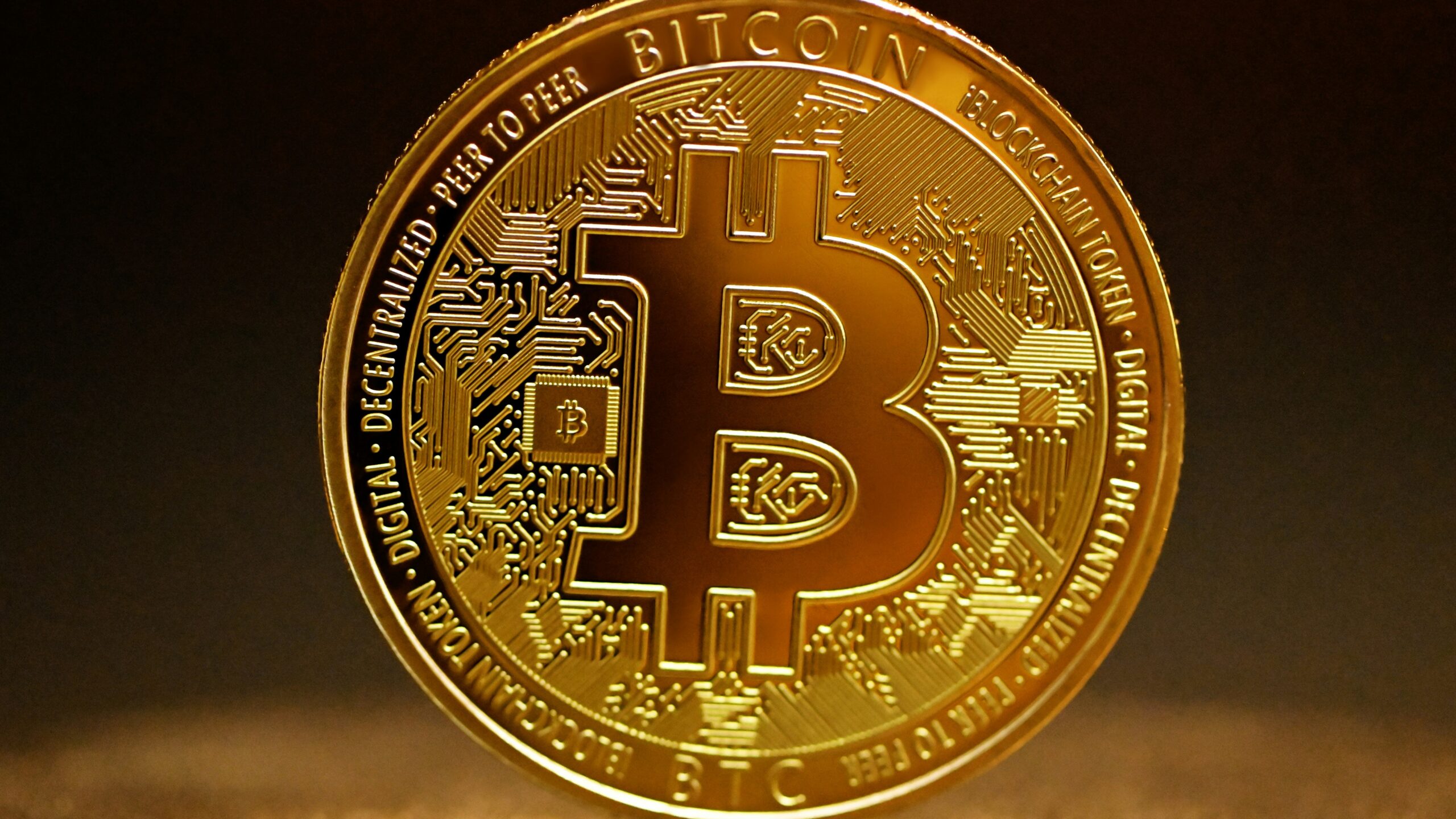 a golden bitcoin sitting on top of a table