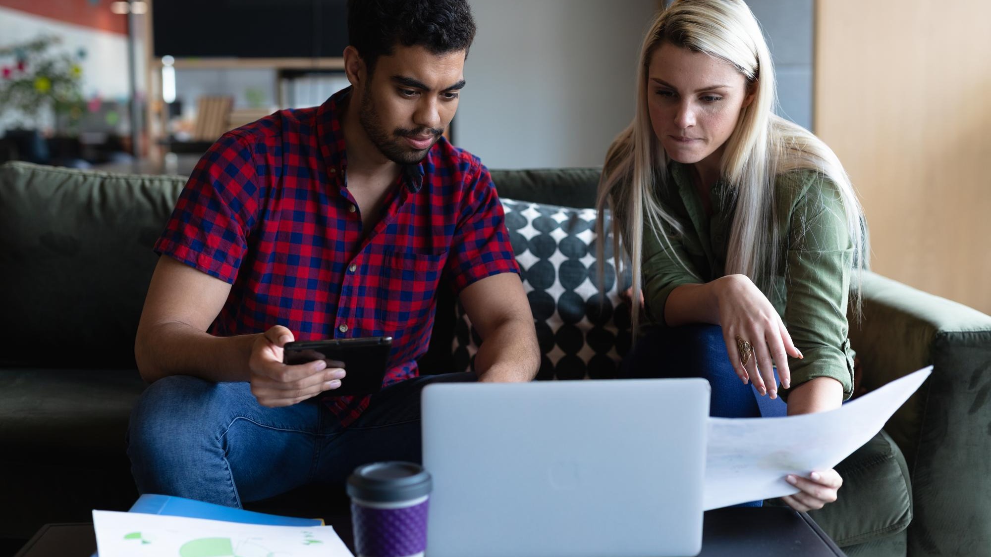 Two diverse business people working in creative office. two people sitting and using laptop. business people and work colleagues at a busy creative office.