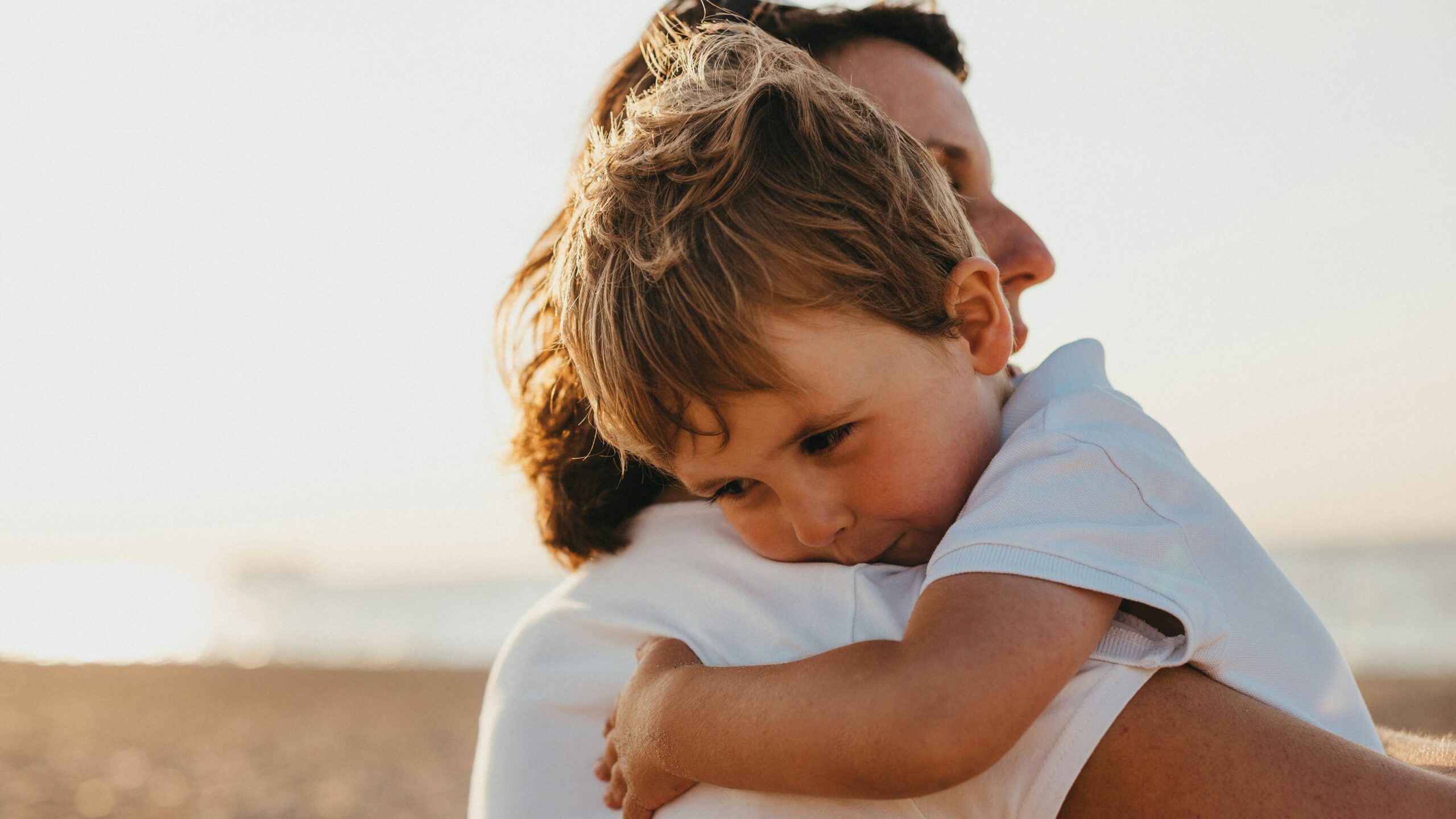 boy hugging woman during daytime
