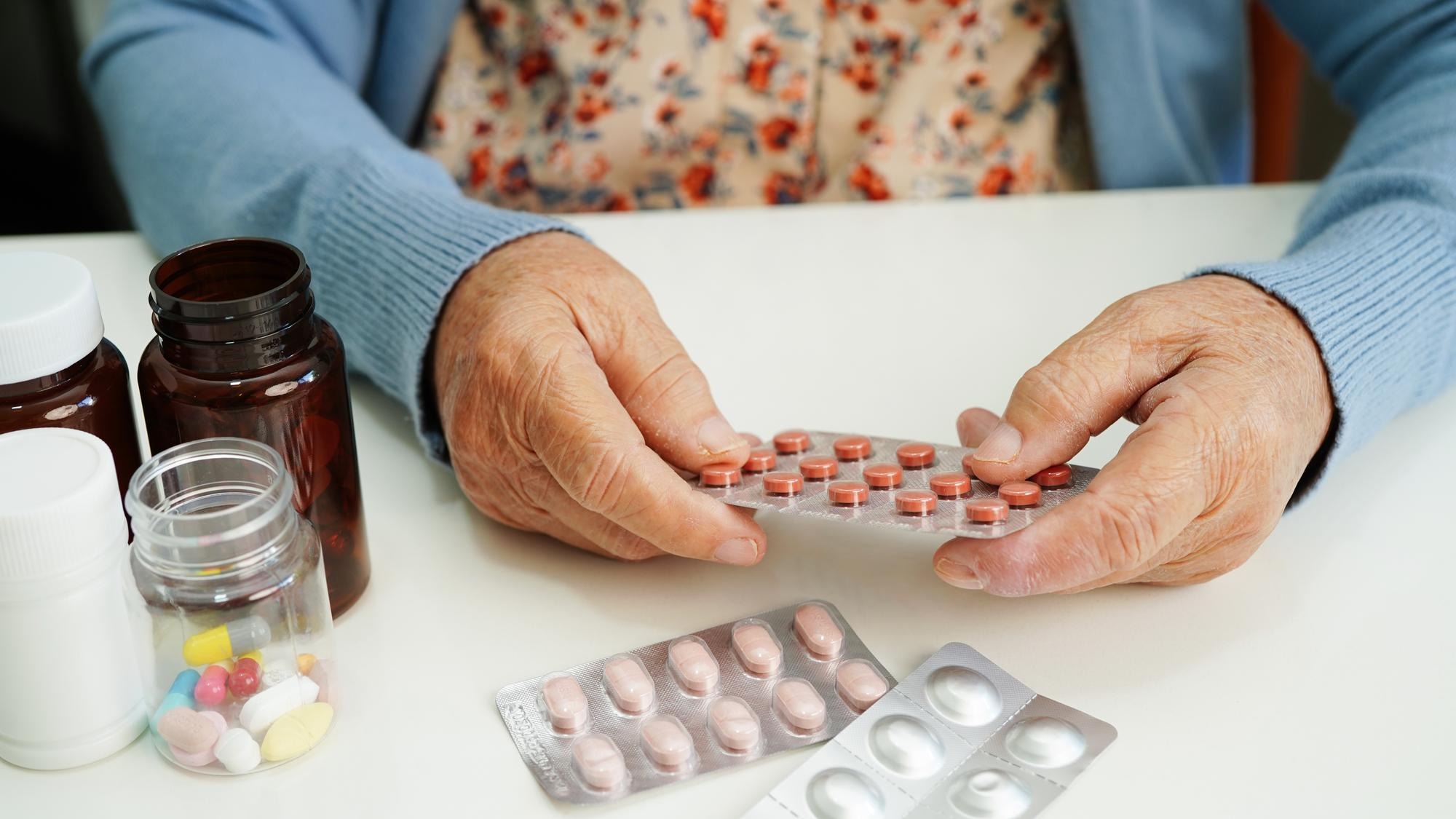 Asian elderly woman holding pill drug in hand, strong healthy medical concept.
