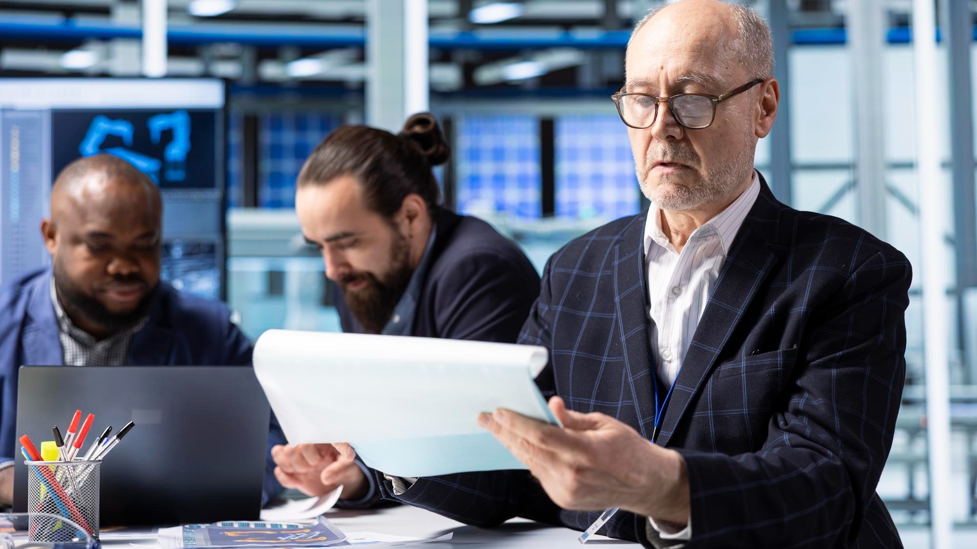 Senior industrial plant shareholder looking at documents analyzing revenue