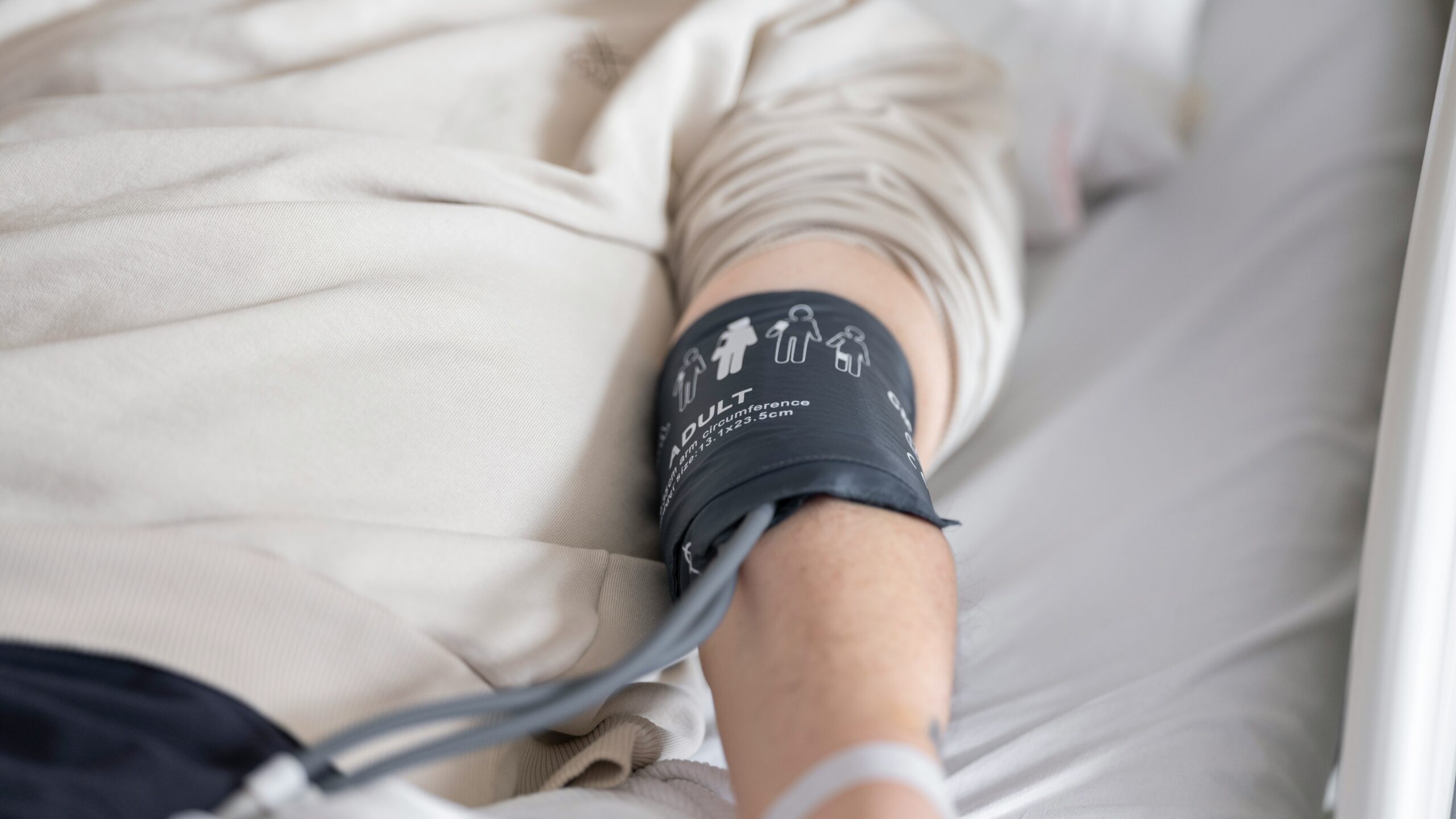 a man laying in a bed with a cast on his arm