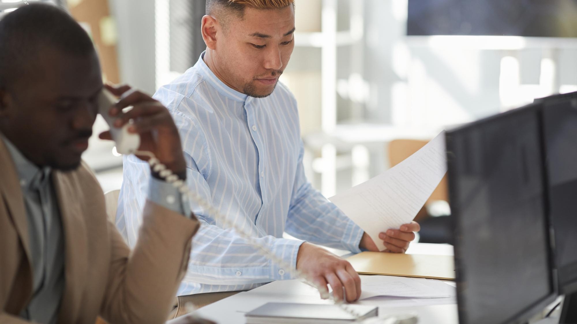Young Asian man working with documents in surveillance center