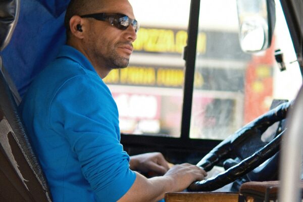 A man sitting in the driver's seat of a bus