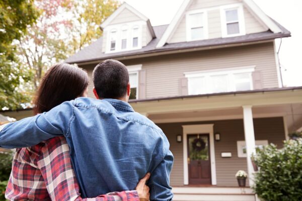 Rear View Of Loving Couple Looking At House
