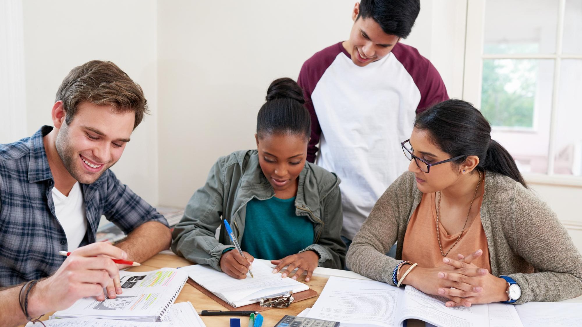 Team students and writing notes in university for learning knowledge or brainstorming together College friends and happy people studying for information education and help for math exam in class