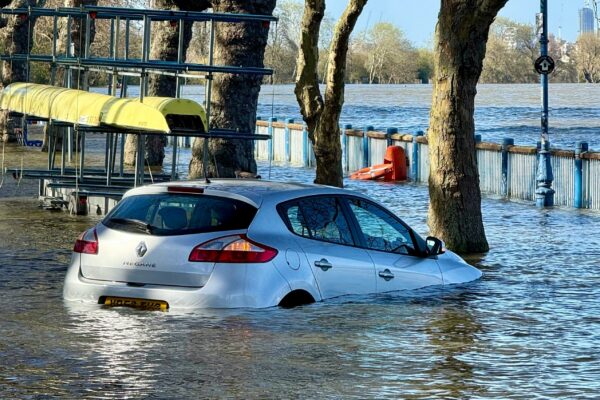 A car is submerged in floodwater.