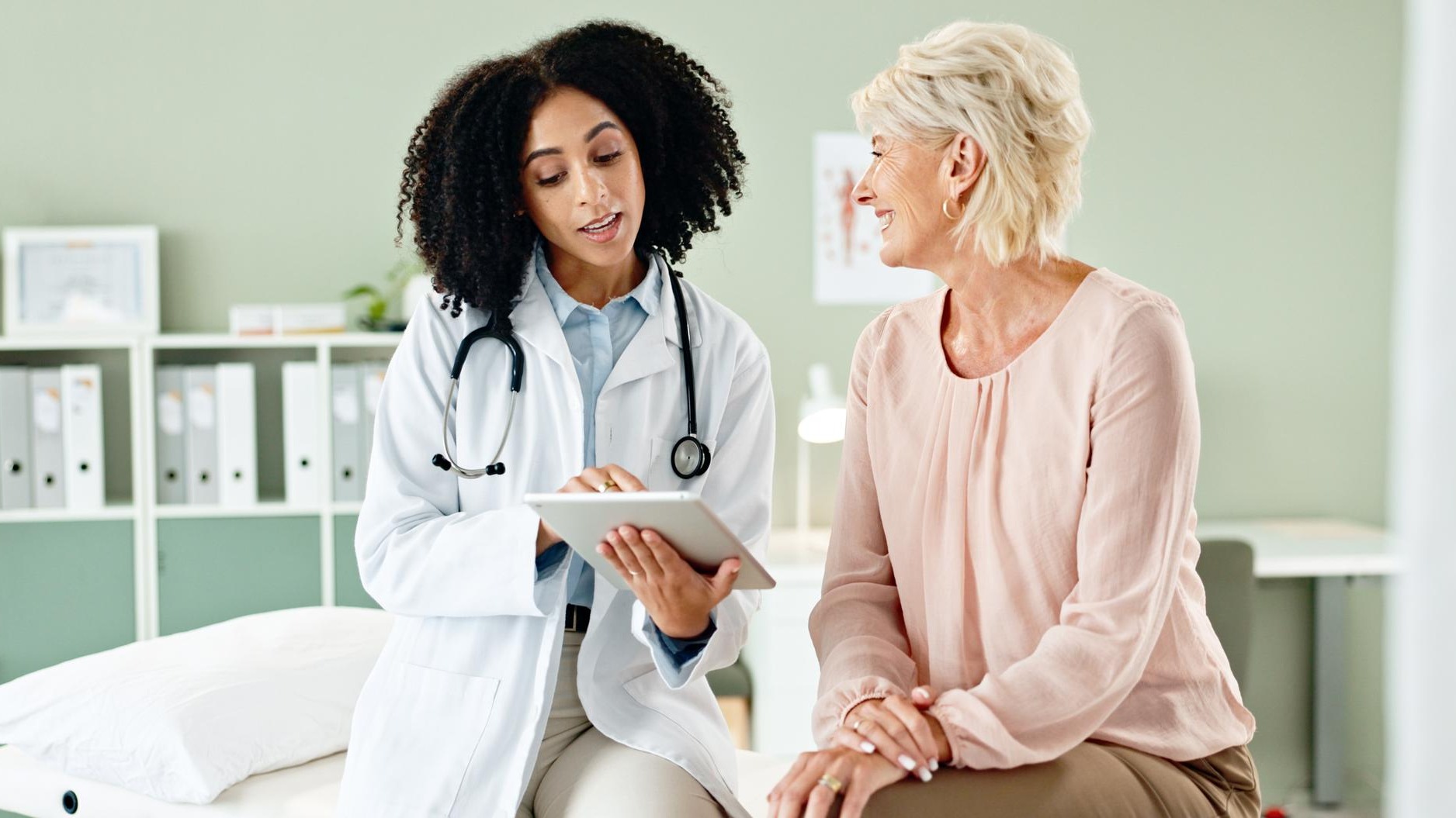 Woman doctor and consulting patient with tablet in checkup for medical results diagnosis or prescription at hospital Female person talking to client for consultation help or advice at clinic