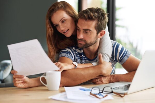 Finance laptop and tax with couple in home together for bank investment or savings Accounting budget or documents for wealth management with man and woman in planning on computer in apartment