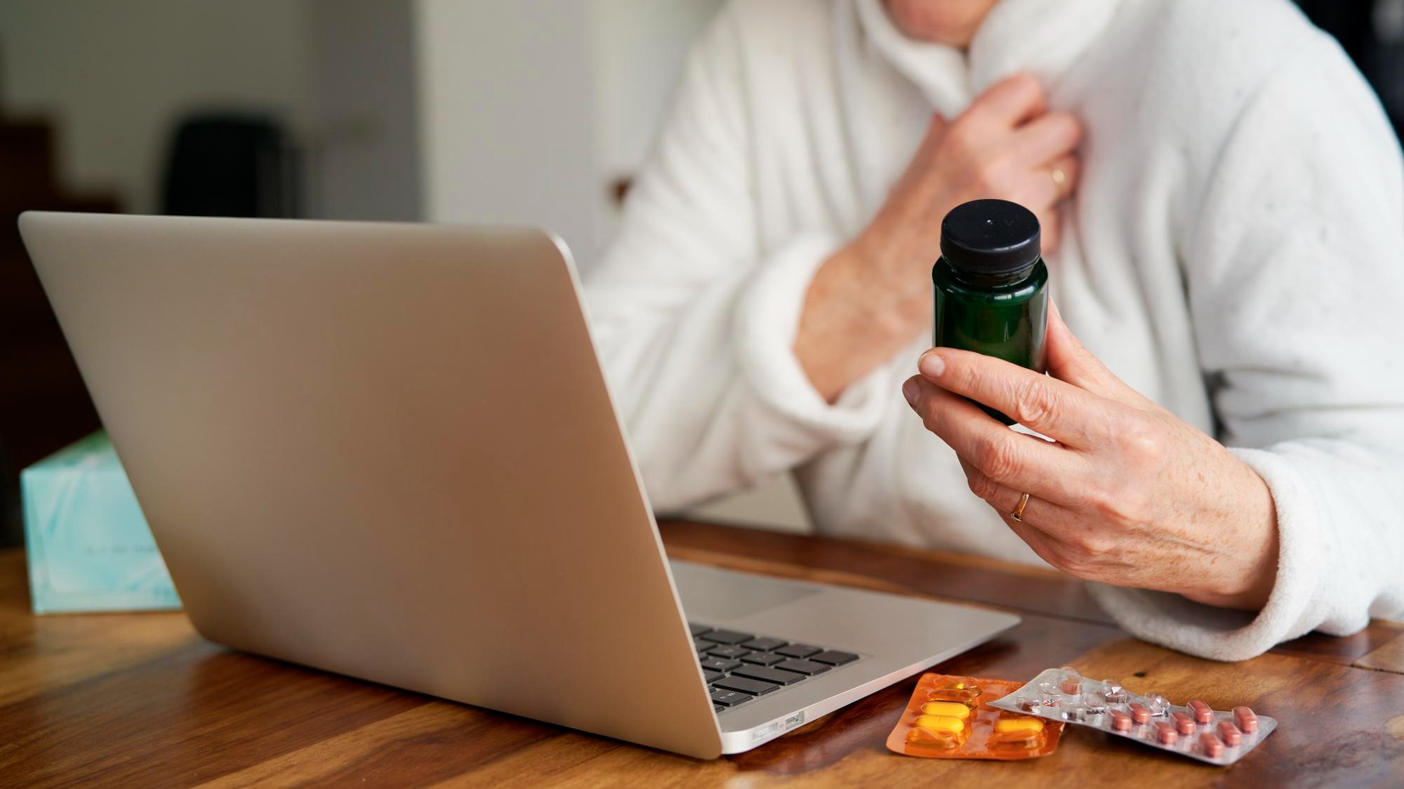 Close up of sick woman consults doctor online using a laptop