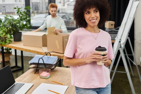 Brightly lit modern workspace featuring individuals packing and sipping coffee during a moving day