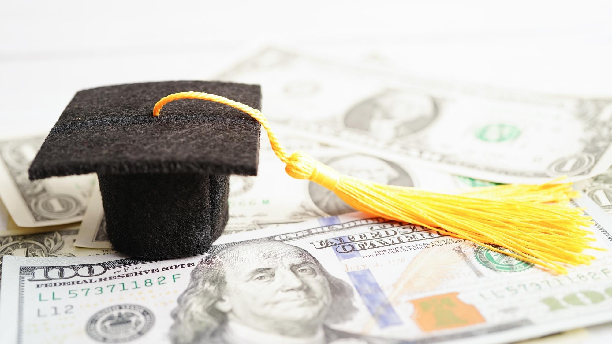 Graduation gap hat on US dollar banknotes money Education study fee learning teach concept