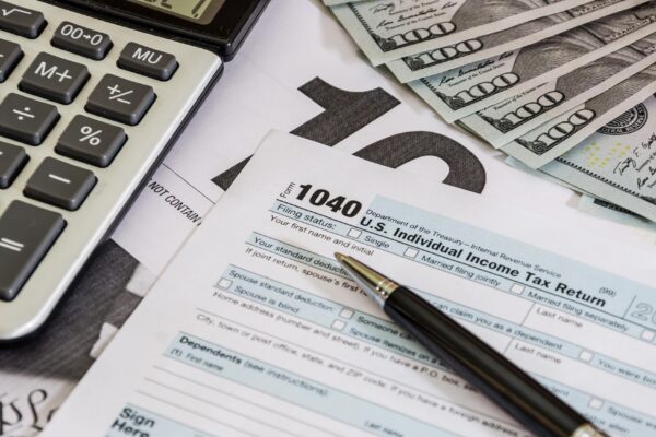 tax forms 1040 and calculator with dollars