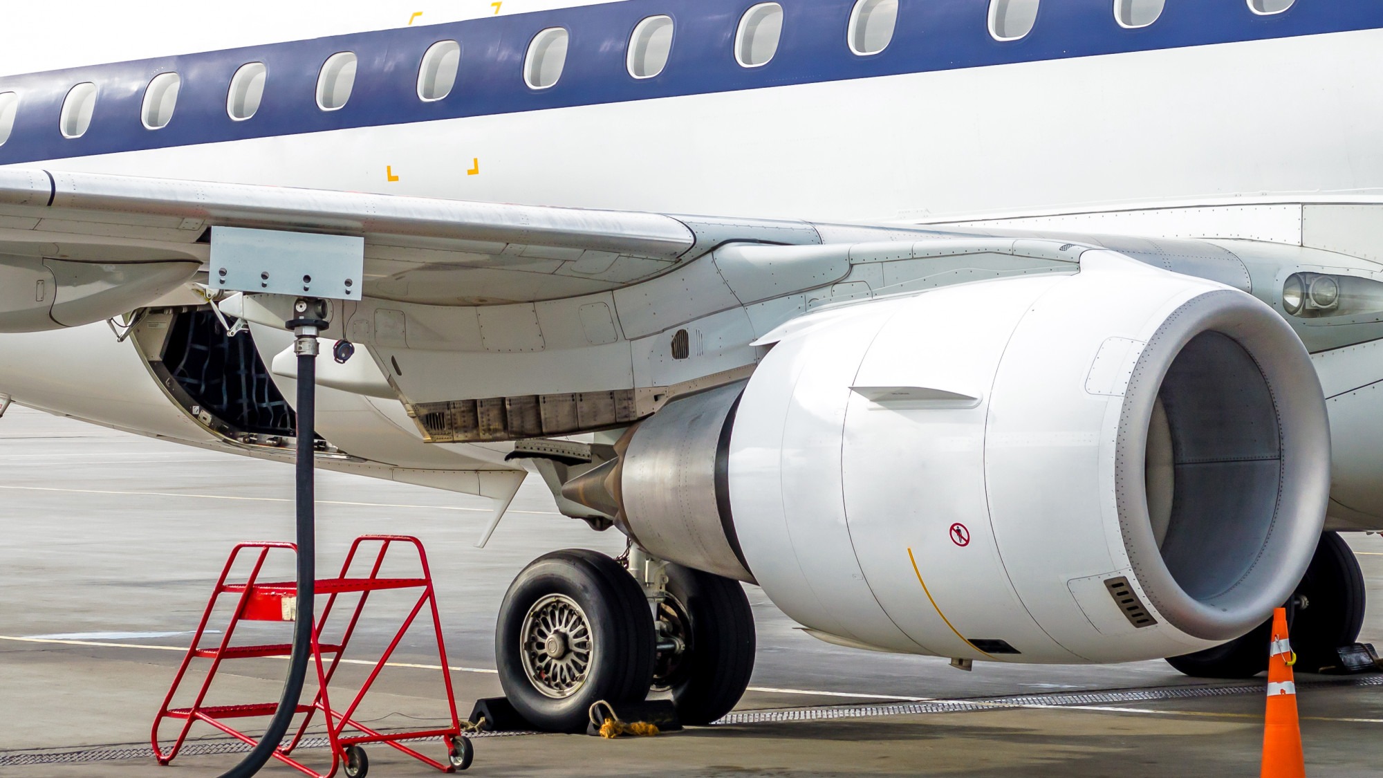 Fueling aircraft, view of the wing, hose, engine. Airport Service.