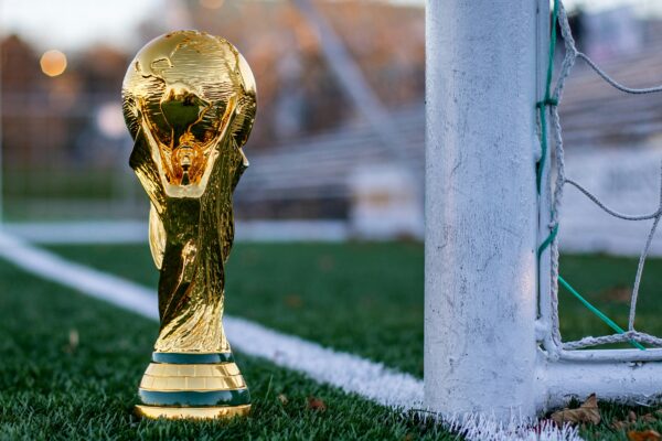 a golden soccer trophy sitting on top of a soccer field
