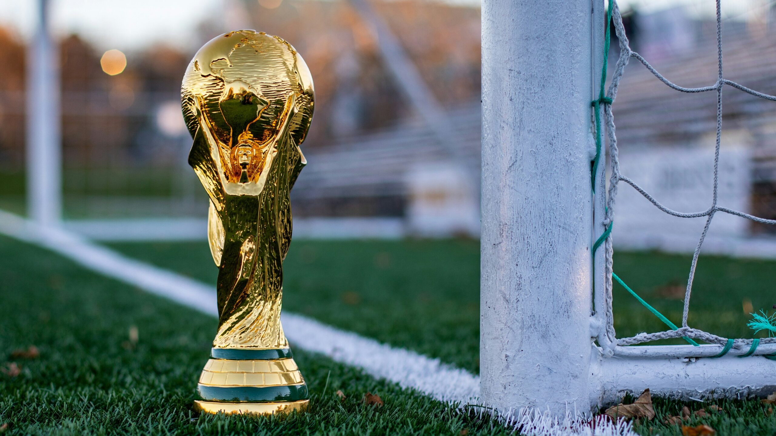a golden soccer trophy sitting on top of a soccer field