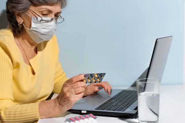 Image Credit: Senior woman with glasses and medical mask reading