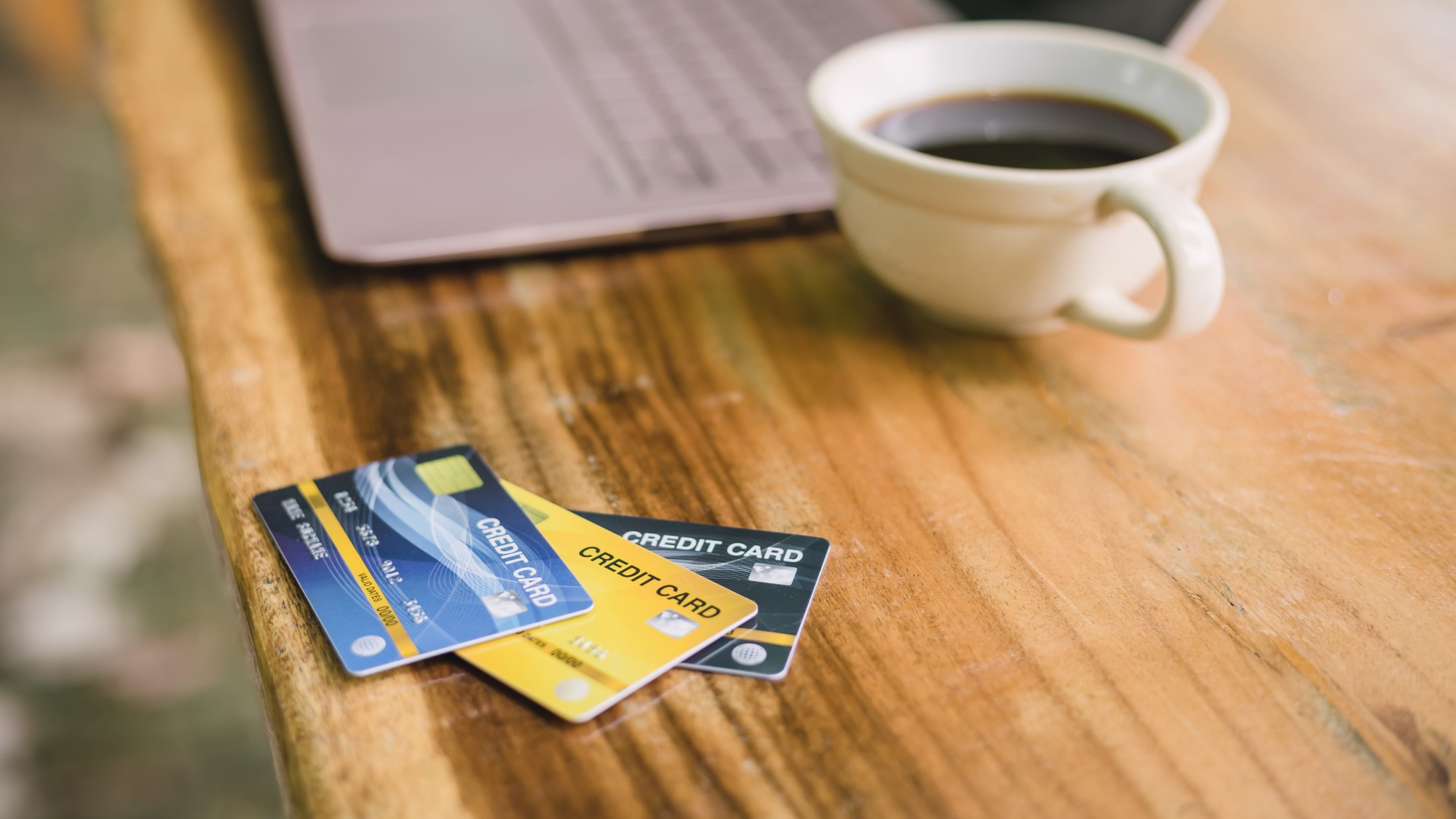 Credit card on laptop with coffee, outdoor