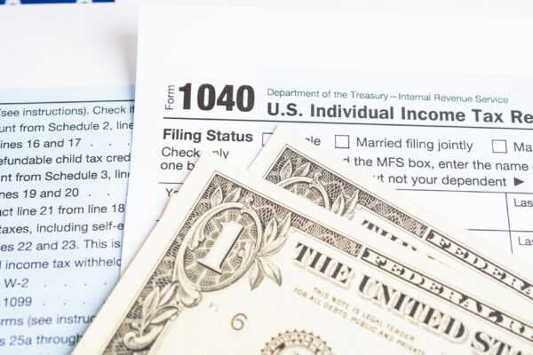 Tax Return form 1040 with USA America flag and dollar banknote US Individual Income