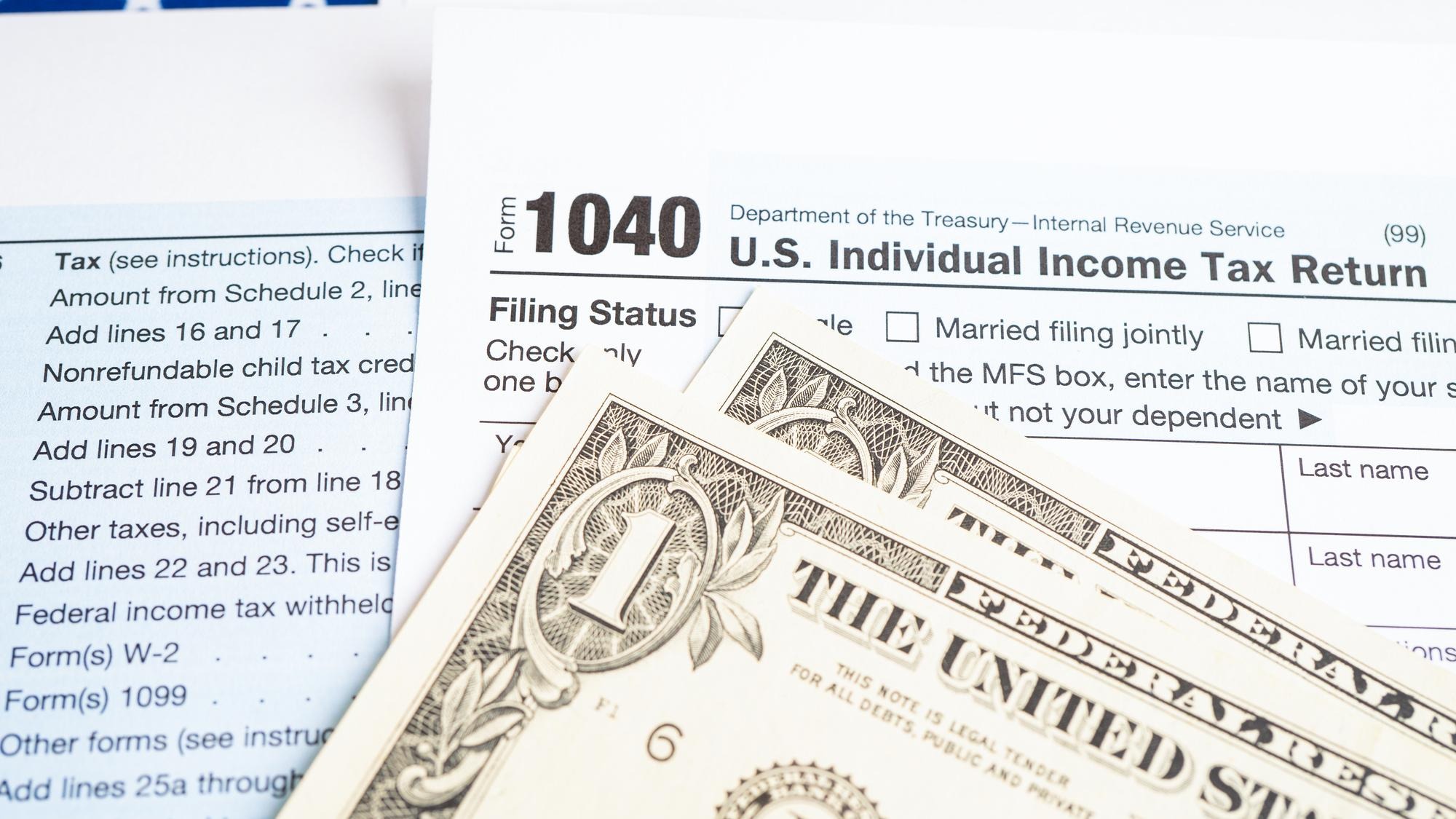 Tax Return form 1040 with USA America flag and dollar banknote US Individual Income